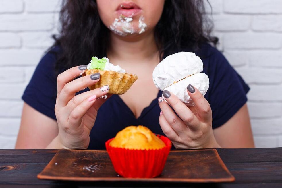 mujer con sobrepeso comiendo dulces